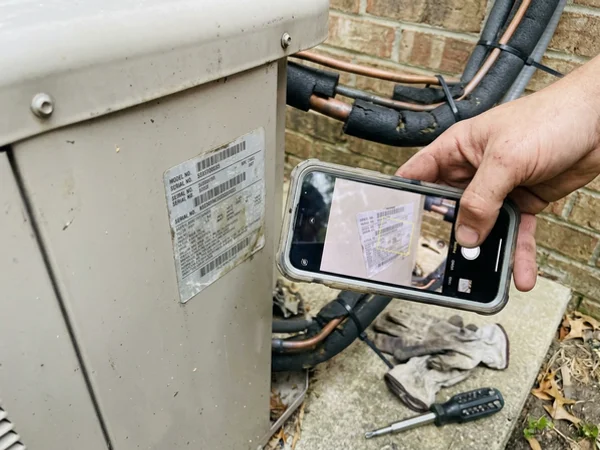 Heat pump nameplate photographed for the rebate application file