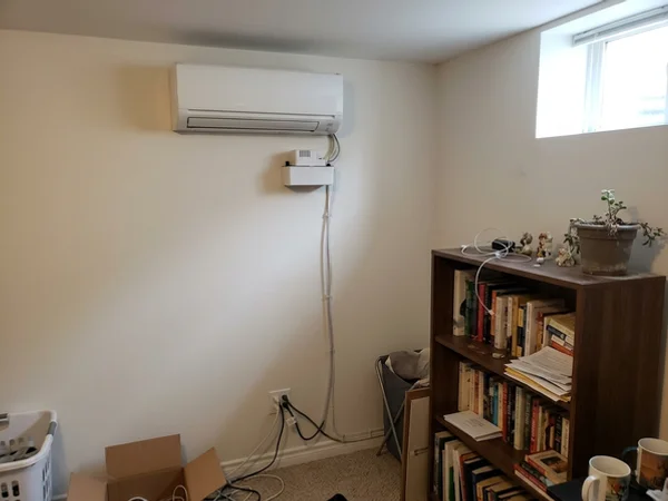 Condensate pump below a mini-split head in a basement suite