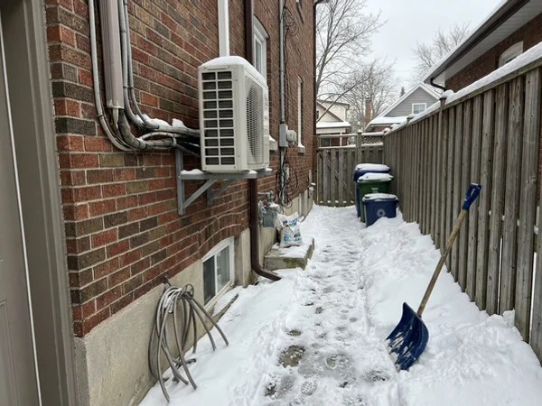 Daikin Fit side-discharge heat pump on a wall bracket above the snow line