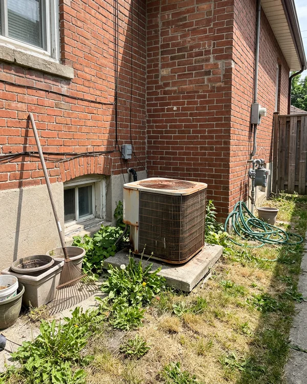 Dead central AC condenser beside a Toronto semi in July