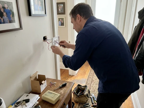 Technician wiring a dual-fuel thermostat
