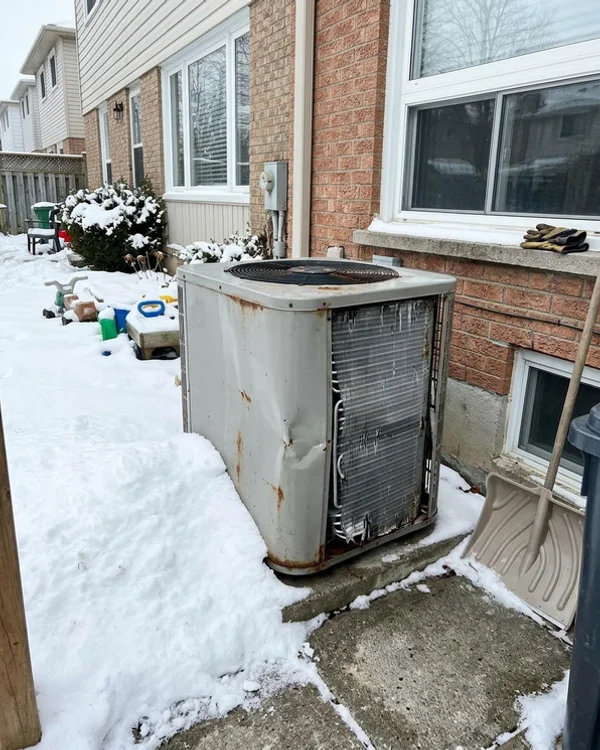 Failed older heat pump outdoor unit with bent fins and rust