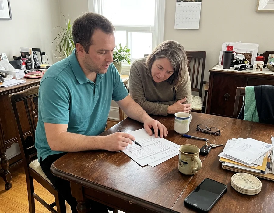 Homeowner and estimator reviewing a written heat pump quote with model numbers