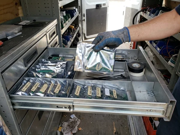 Mitsubishi replacement parts organized in a service van drawer
