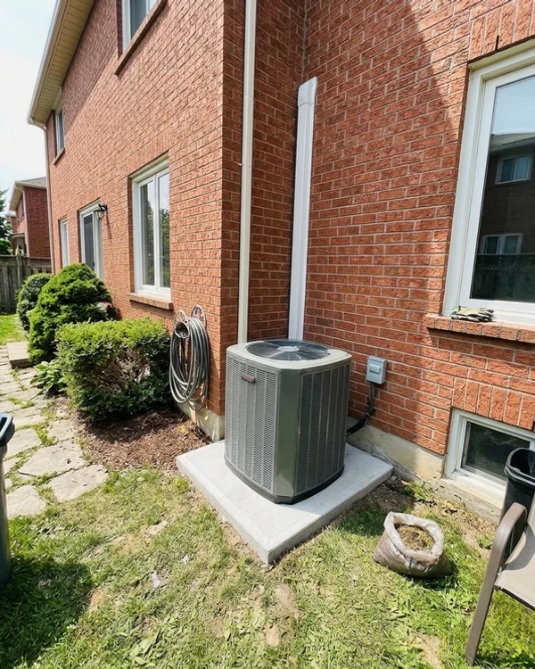 New central heat pump beside the same house after the retrofit