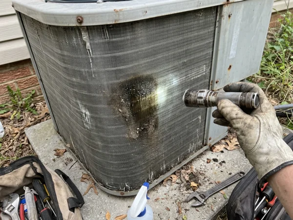 Oily residue on the outdoor coil indicating a leak