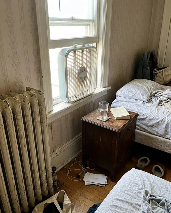 Old cast iron radiator and window fan in a Victorian Toronto apartment