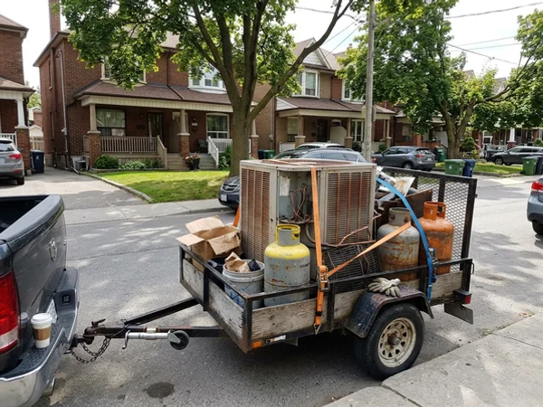 Recovery cylinders and the old heat pump loaded for proper disposal