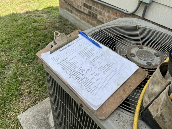 Service checklist with refrigerant and amp readings on the outdoor unit