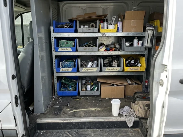 Service van shelving stocked with labelled commercial heat pump parts